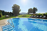 Sommerurlaub im 4 Sterne Wellnesshotel Bayerischer Wald. Badem im beheiztem Außenpool mit Blick auf Wald und Natur